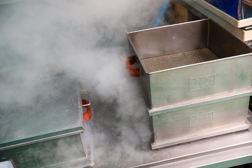 A whole snow crab cooking in the steamer as the steam rises