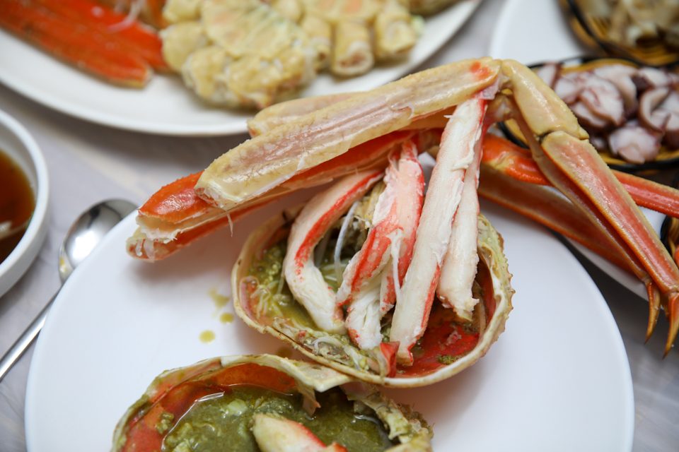 A steamed snow crab just before coming out, its reddened legs lined up neatly