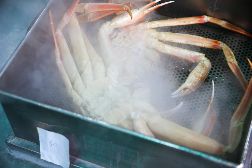 김이 가득 찬 찜기 안에 대게가 배를 위로 하고 놓여 있는 모습