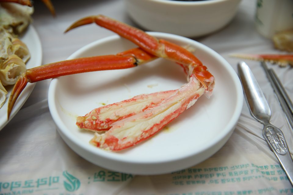 대게 다리를 가운데 두고 반찬 그릇이 줄지어 놓인 상