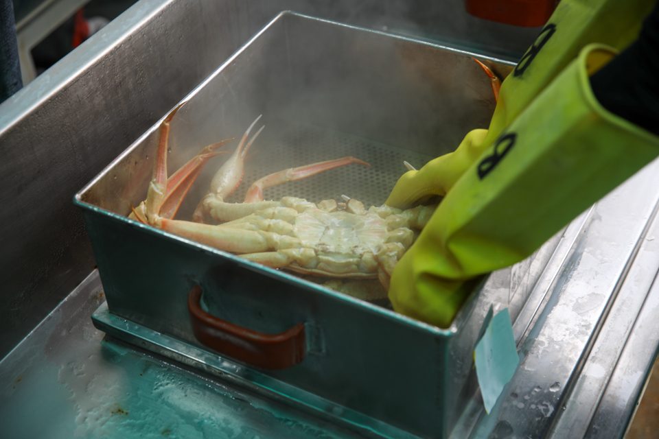 주방 안쪽 찜솥에서 김이 세차게 솟는 조리 장면