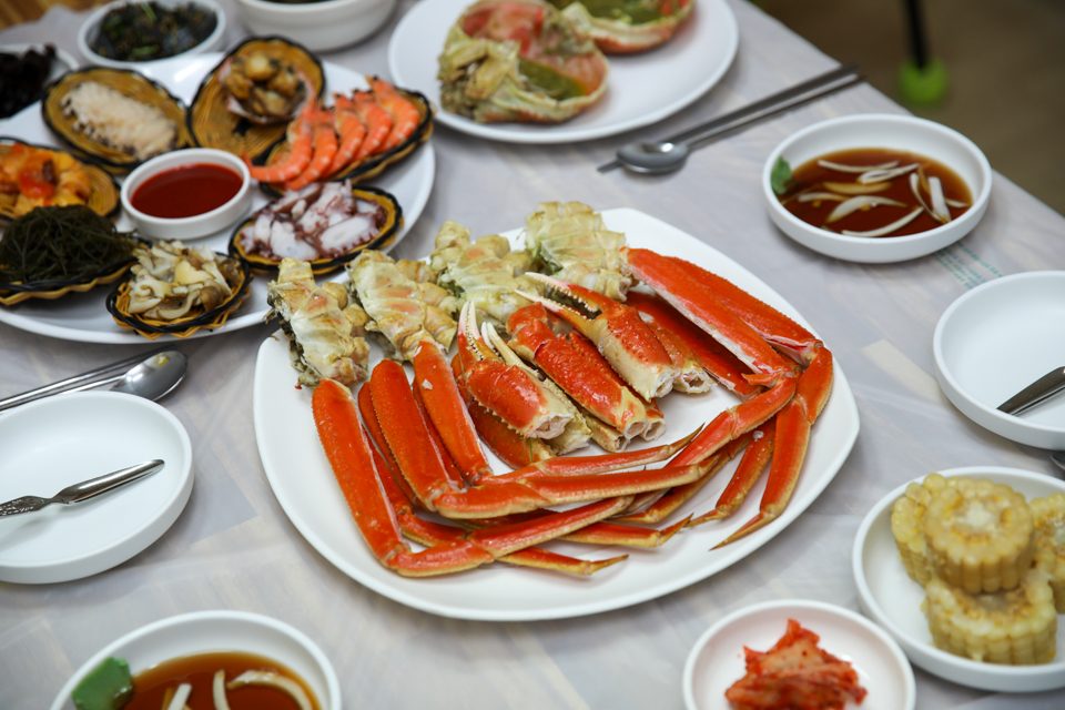 가운데 놓인 대게 다리 접시 둘레로 작은 반찬 그릇들이 자리 잡은 상차림