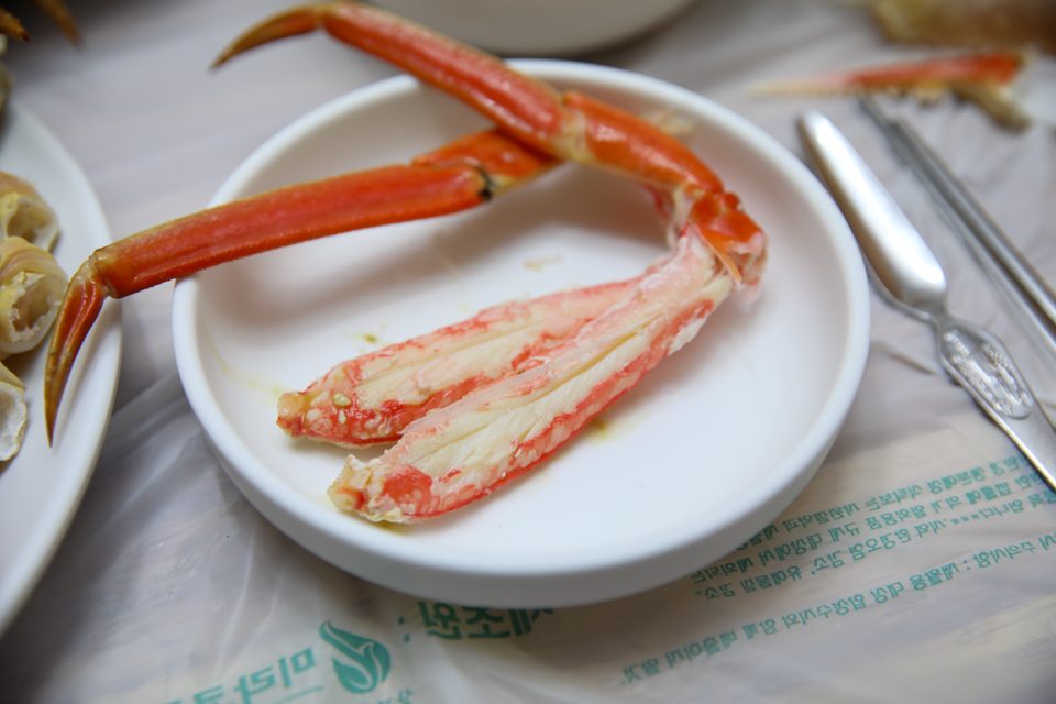 대게 다리 한 접시를 여러 곁들임이 받치는 상차림