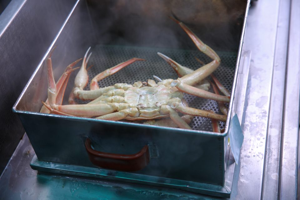 흰 증기 줄기가 찜솥 위로 솟구치는 조리 현장
